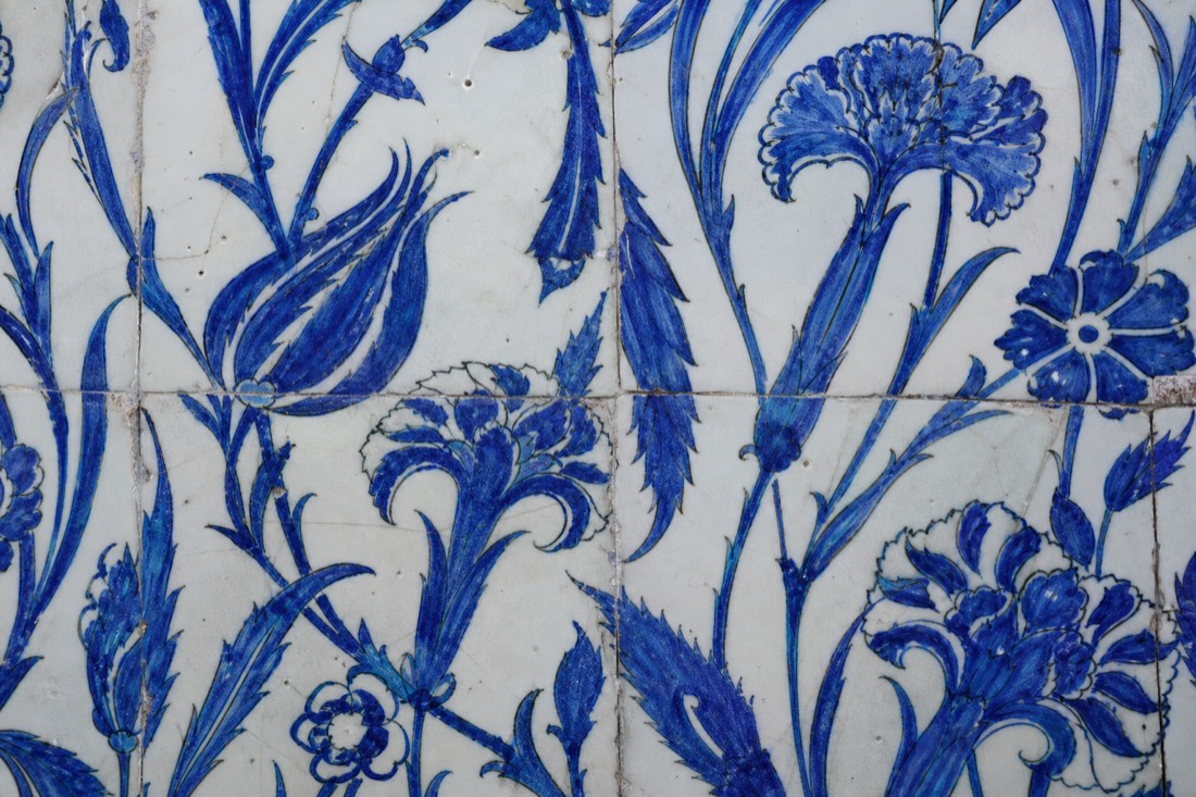 Extreme close-up of an Iznik tile tulip-and-carnation motif in cobalt blue on white
