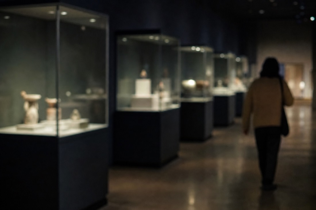 Dim gallery inside the Topkapi Palace treasury with glass display cases glowing in low light