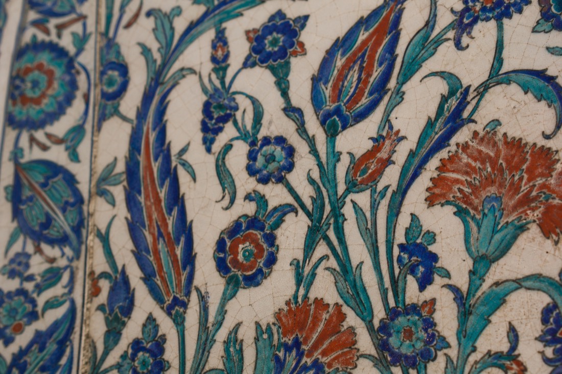 Extreme close-up of a blue-and-green Iznik floral tile panel on a Topkapi Palace wall