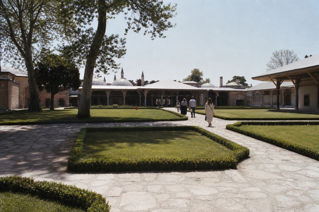 Third courtyard lawn and pavilions of Topkapi Palace with a few distant visitors at midday